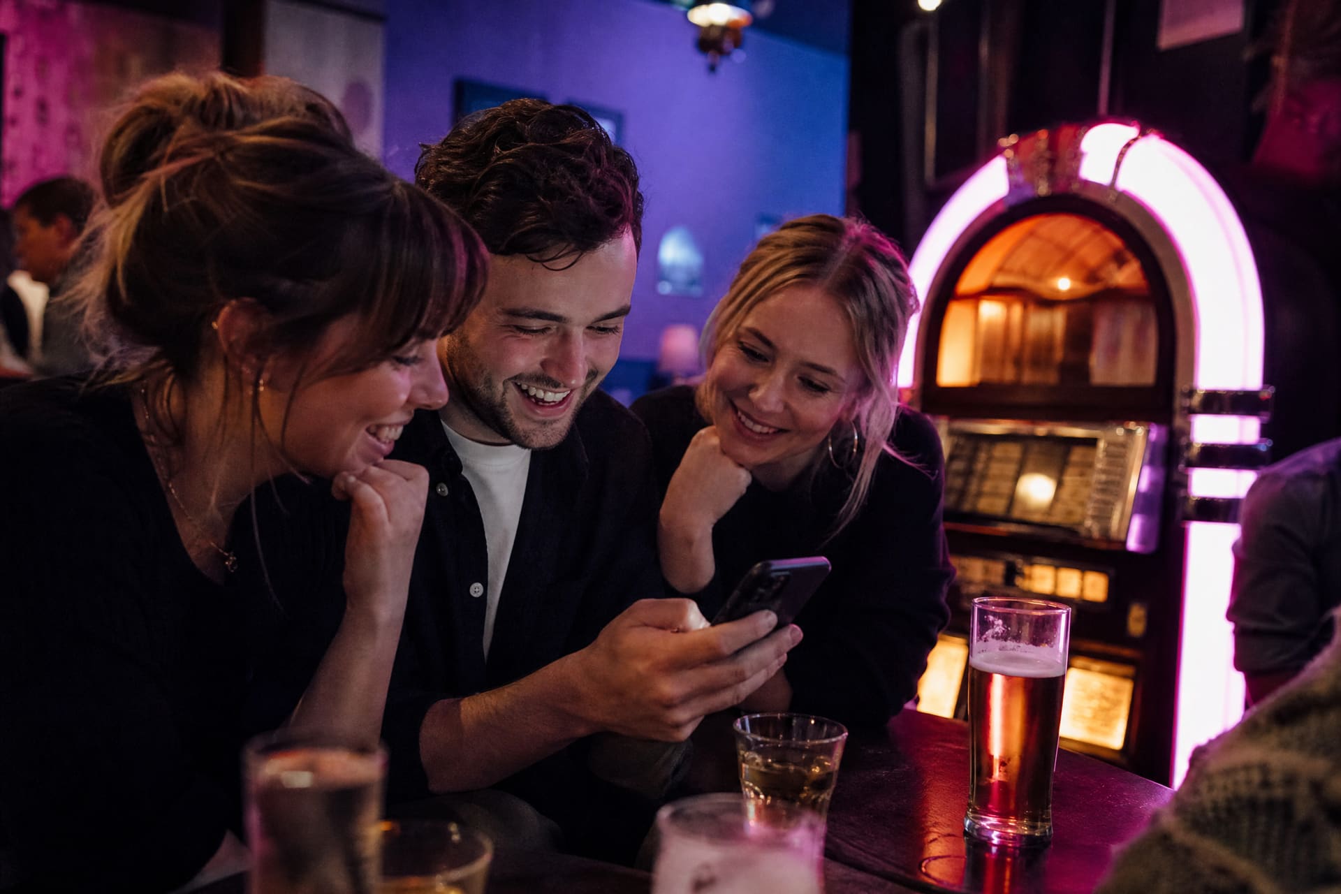 Friends choosing music together in a bar