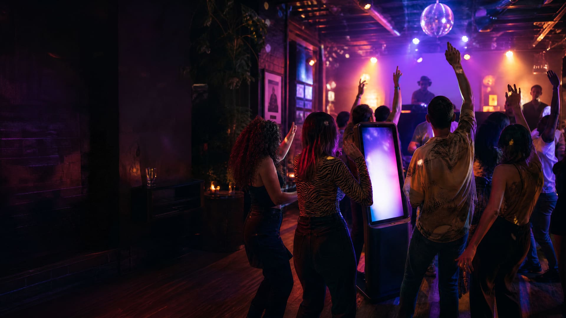 A lively bar crowd dancing around a jukebox